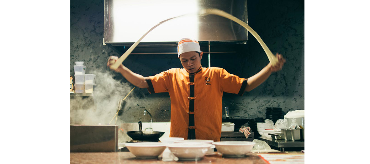 An Asian cook making pasta 