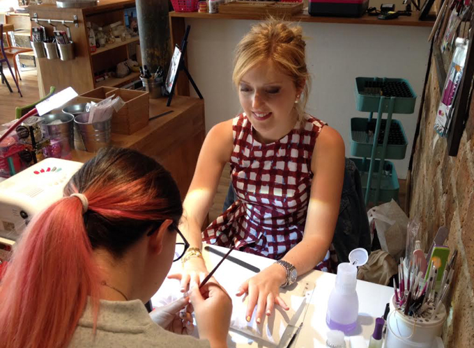 Nail Bar customer drying her nail polish on her hands at the Nail Bar