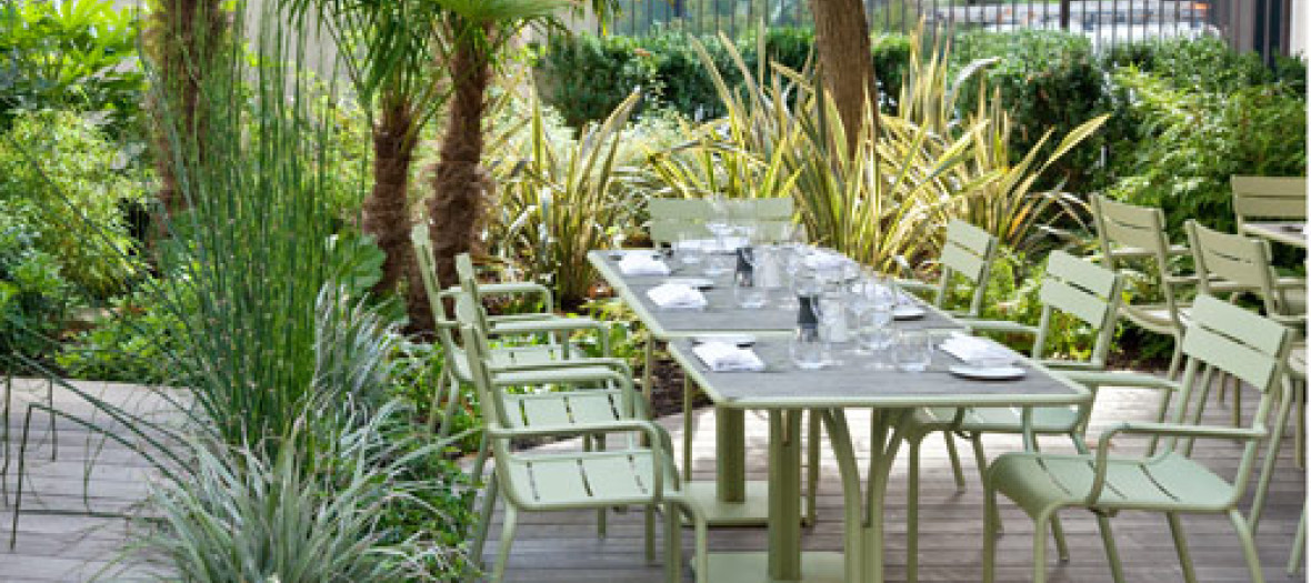 The outdoor protected terrace of the Blind Bar and its super green decor