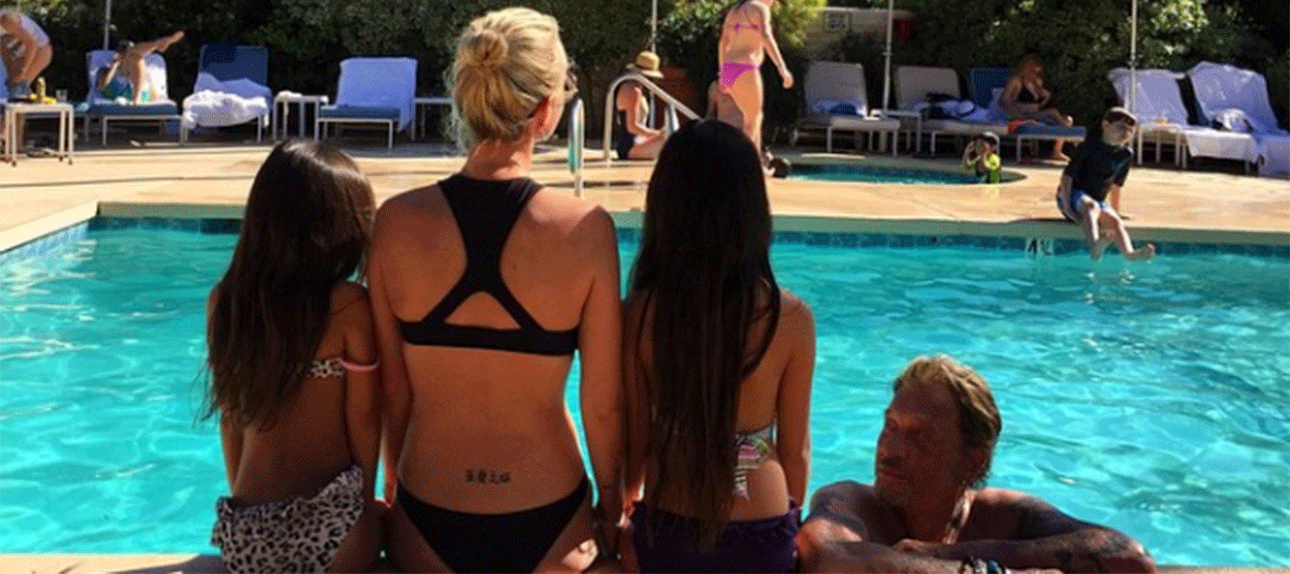 Laeticia Hallyday with her daughters and her husband on the edge of the swimming-pool