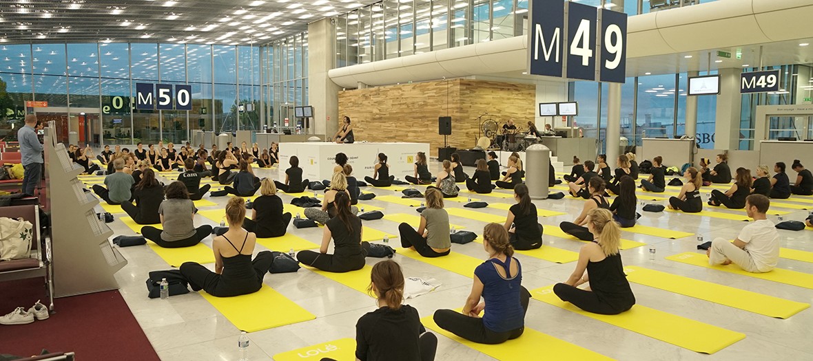 personnes faisant du yoga en salle d'embarquement