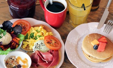 Plats de salade, toasts, jus de fruit, café, confiture, jambon