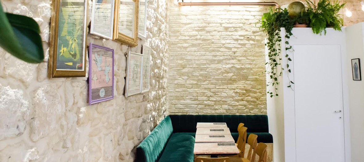 Coffee shop à Paris avec décoration composée de marbre rose, banquette en velours vert, dessins Love signés Yves Saint Laurent
