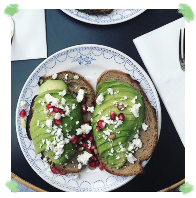 Avocado toast avec fromage frais, grenade et salade de roquette