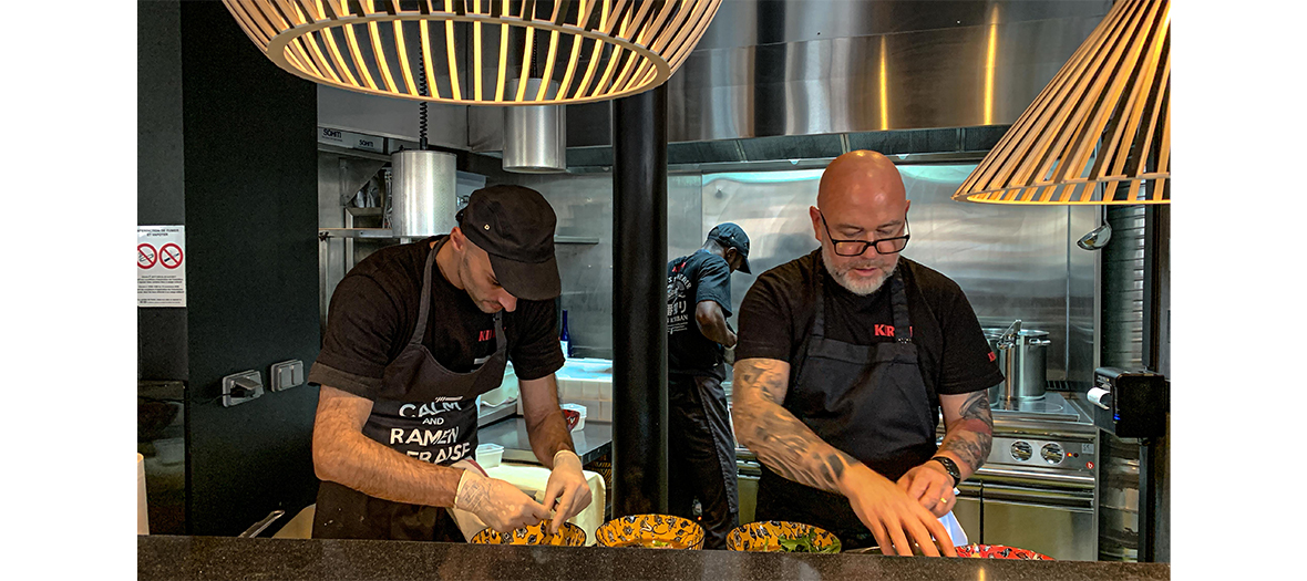 Portrait of chef Guy Savoy and his team preparing a dish of broth