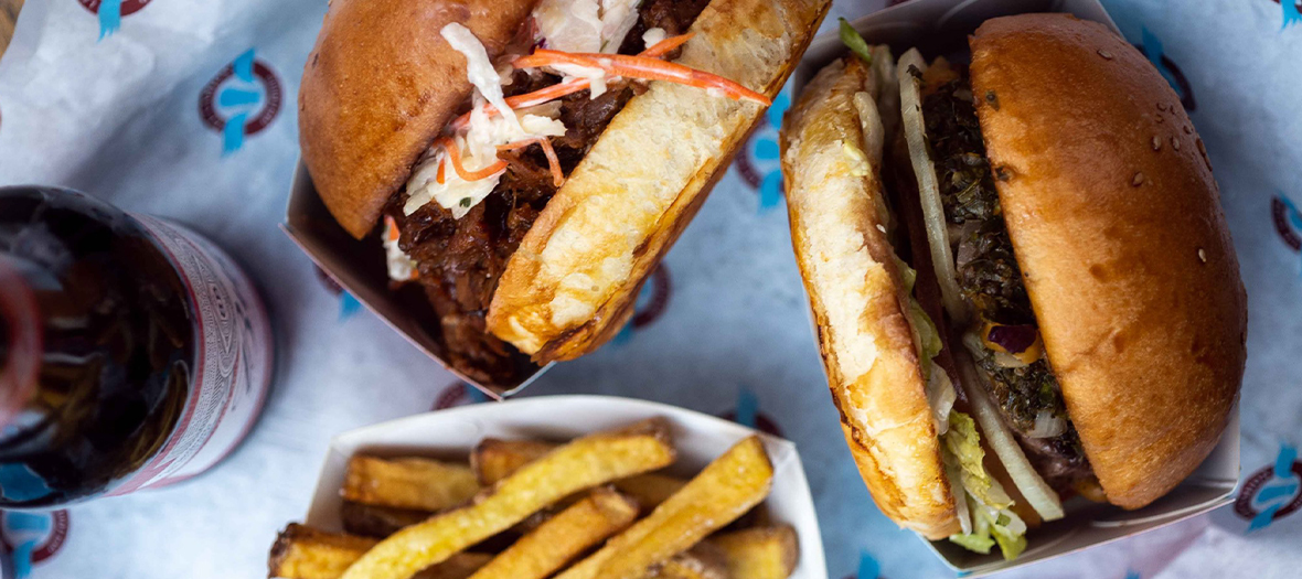 Plat de burgers avec Bœuf haché, cheddar affiné, oignons caramélisés, bacon, beignet d’oignons, sauce barbecue, mayonnaise et Frites