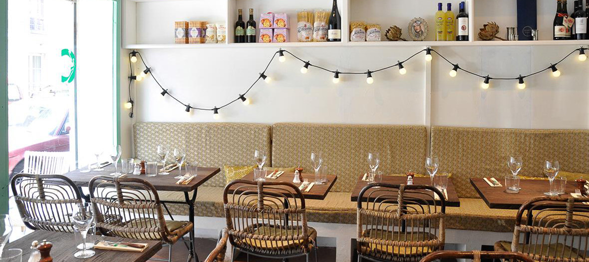 Decoration of the restaurant La Cicciolina with lights, bottles and glasses of wine, tables and chairs