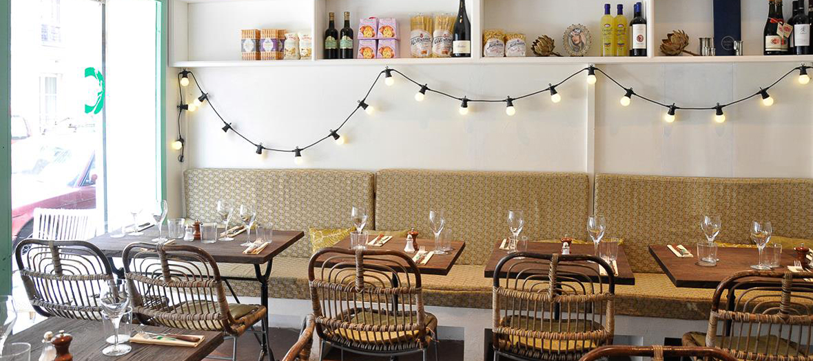 Décoration du restaurant La Cicciolina avec des lumiéres, bouteilles et verres de vins, tables et chaises