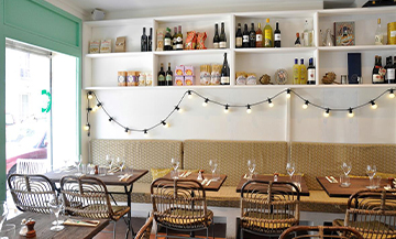 Decoration of the restaurant La Cicciolina with lights, bottles and glasses of wine, tables and chairs