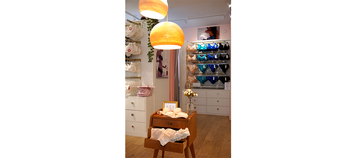 Interieur de la boutique Fillandises avec des bralettes, corbeilles noires en dentelle, culottes taille haute, bodiest-shirts à messages, shorts de pyjama