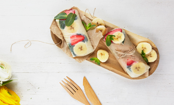 Rouleaux de printemps avec banane, galette de riz, du lait entier, des fraises et des feuilles de menthe 