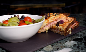 Le Croque Monsieur au jambon à la truffe et gruyère râpé et un bol de salade de la cheffe Juliette de l’Hôtel Parister