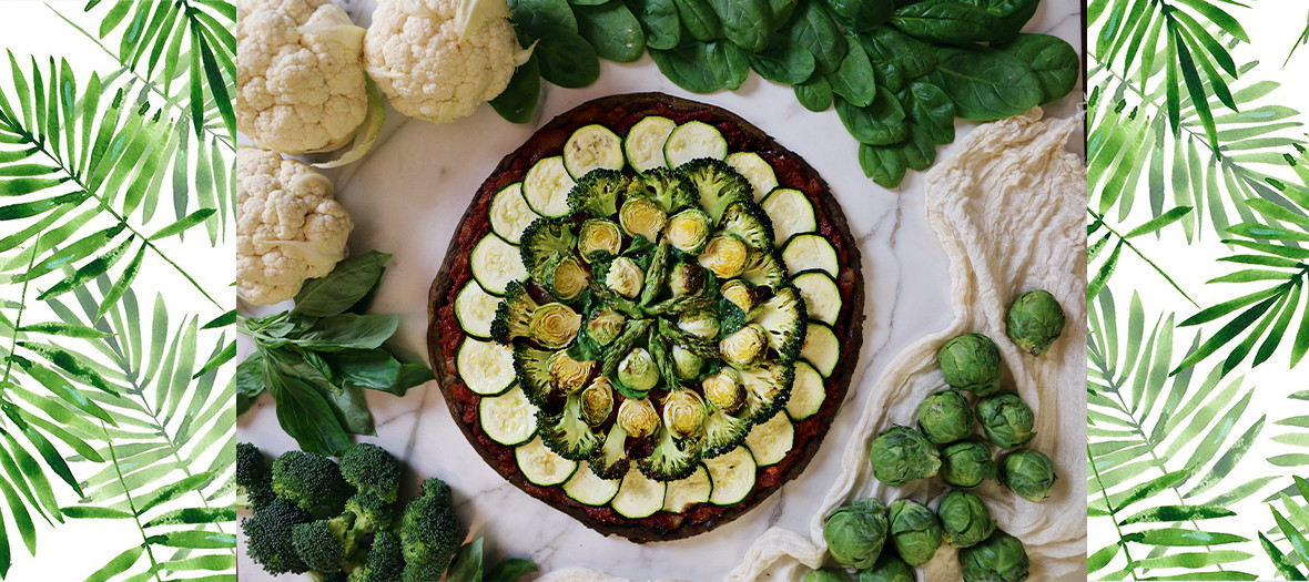 Low calorie pizza with cauliflower, broccoli, zucchini, asparagus, goat cheese, egg, spirulina, minced basil, tomato puree