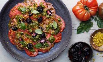 Une salade de tomates, de basilic, pistaches, fleur de sel et de poivre