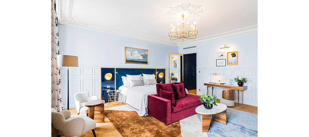 Standard bedroom in hotel powers with Art Deco headboard and lighting fixtures, made-to-measure armchairs of the 50’s Scandinavian period, contemporary chandeliers, Napoléon III mirrors, fireplace in sculpted marble.