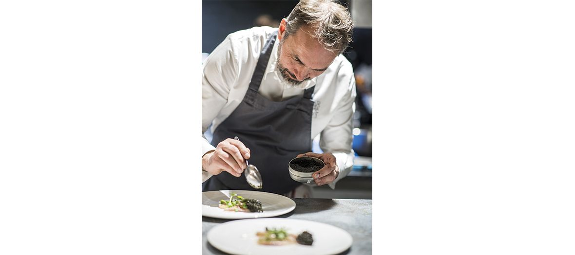 Chef étoilé Christophe Aribert préparant un plat avec du caviar