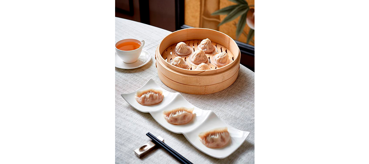 Verre de thé et plat de xiao long bao fourré de porc du restaurant Imperial Treasure