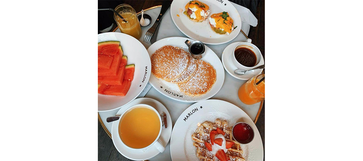 XXL pancakes with maple syrup, oversized waffle topped with chocolate hazelnut and whipped cream sauce, squeezed fruit juice, watermelon slices, sandwich with cream cheese and becon from Marlon Brunch