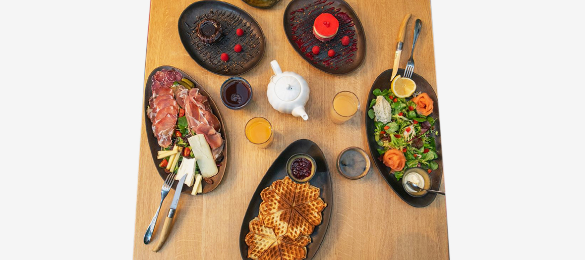 Brunch from Assemblages that includes Fresh fruit juices, such as apple-pineapple from the extractor, a Norwegian waffle with cardamom, a fruit salad and a nice charcuterie plate with ham from Auvergne, Corsican coppa, refined A.O.C. cheese or smoked salmon and tarama