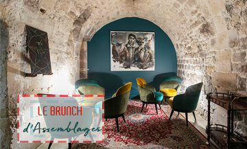 cave à vins du Brunch Assemblages avec une déco cosy parfaite qui mixe mur en pierre, mobilier moderne, tableaux arty et tapis persans