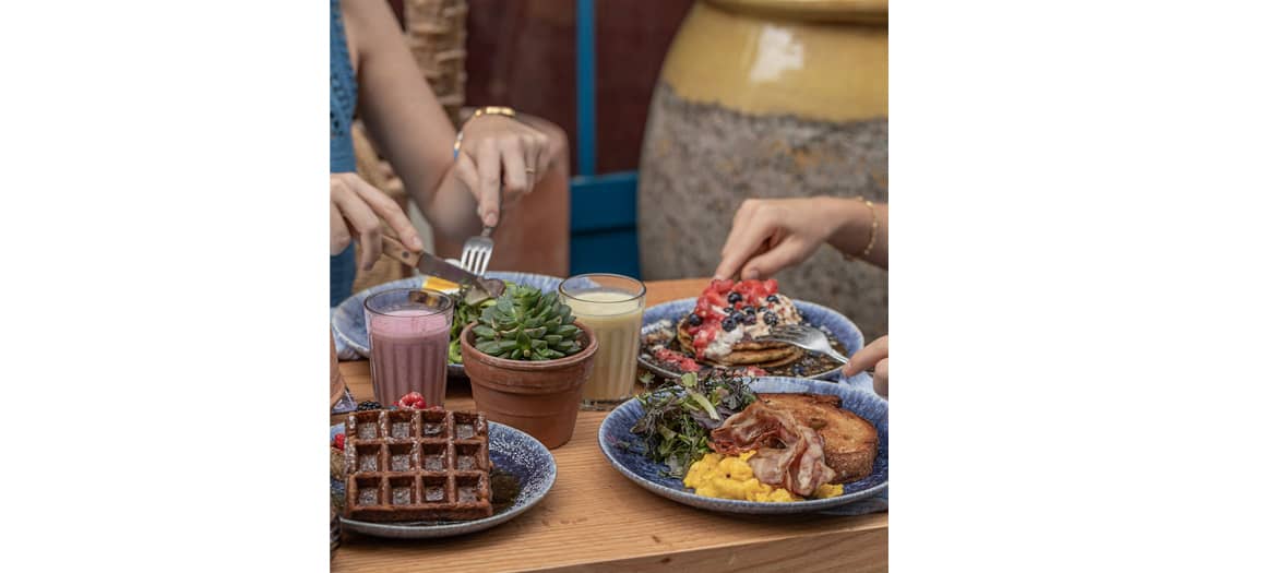 Le brunch de chez Cali Sisters avec des pancakes, un granola, des œufs brouillés, bacon croustillant et le green shakshuka.