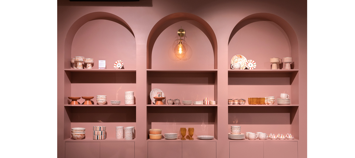 Shelves filled with beautiful pink dishes and imposing Art Deco brass lights at NV GALLERY