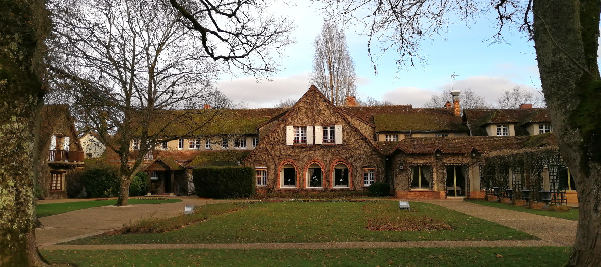 Facade with a lawn in the garden of the Auberge des Templiers