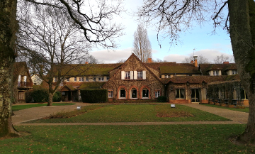 Facade with a lawn in the garden of the Auberge des Templiers