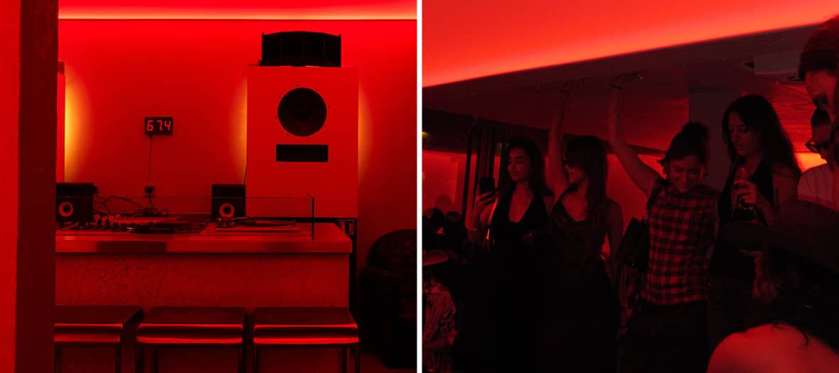 Espace lounge d&rsquo;un club parisien avec &eacute;clairage rouge et ambiance intimiste.