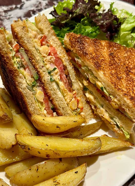 Club sandwich végétarien du restaurant Le Daimant Saint-Honoré à Paris, servi avec pommes de terre rôties.