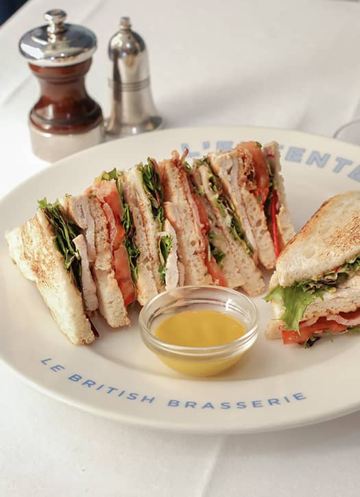 Club sandwich british de L’Entente à Paris, servi avec sauce et salade.