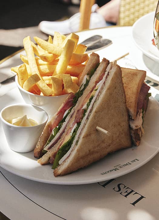 Club sandwich classique de la brasserie Les Deux Magots à Paris, accompagné de frites maison.
