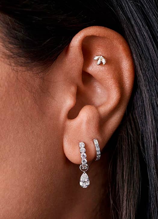 Piercing d’oreille signé Maria Tash avec bijoux en or et diamants à Paris.