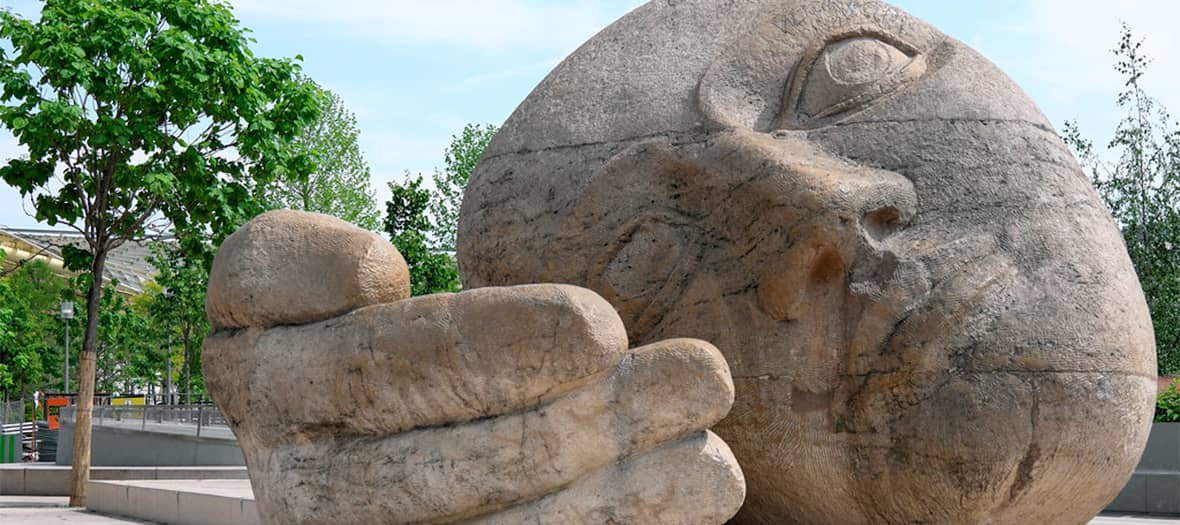 Sculpture monumentale "Écoute" d’Henri de Miller représentant une tête et une main, située place René-Cassin à Paris.