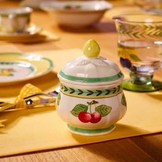 Sucrier en céramique décoré de cerises, posé sur une table aux couleurs estivales