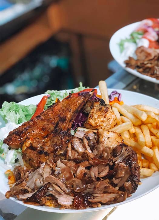 Assiette kebab &agrave; L&rsquo;&Icirc;le de Cr&egrave;te &agrave; Paris avec viande r&ocirc;tie, frites, salade et sauce blanche, sp&eacute;cialit&eacute; grecque parmi les meilleurs kebabs de Paris.