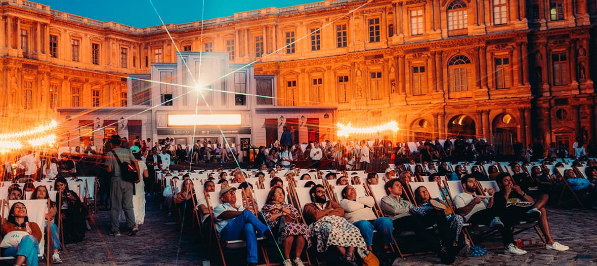 Séance de cinéma Paradiso au Louvre à Paris, dans la cour du musée avec transats et projection nocturne.