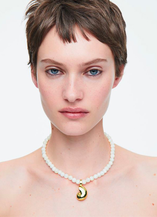 Un collier blanc et pendentif coquillage 
